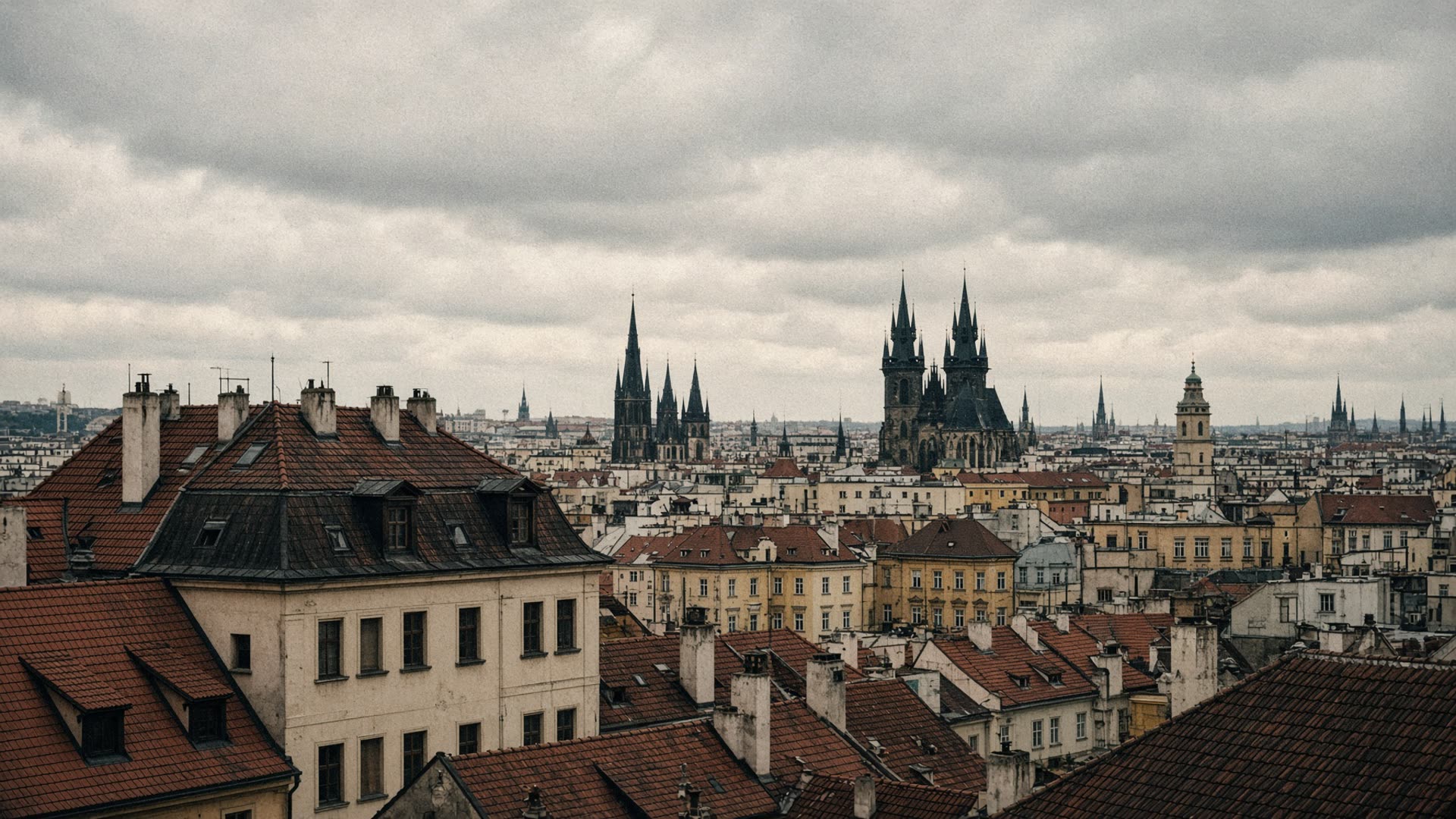 Overcast Prague rooftops and distant spires
